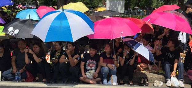 2016年10月14日にタイの王の葬列を待つバンコクの通りを並べている哀悼者